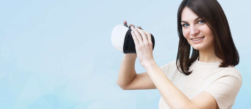 side-view-smiley-woman-holding-virtual-reality-headset-2